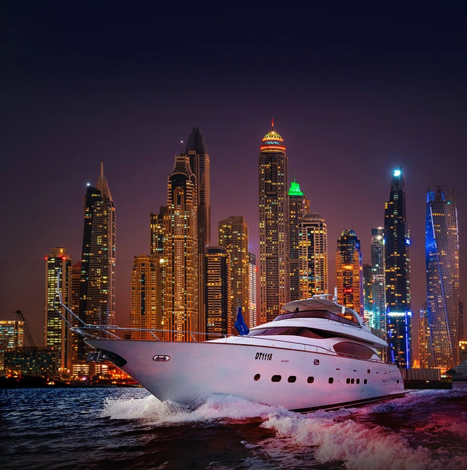 A yacht in front of the Dubai Marina towers at night